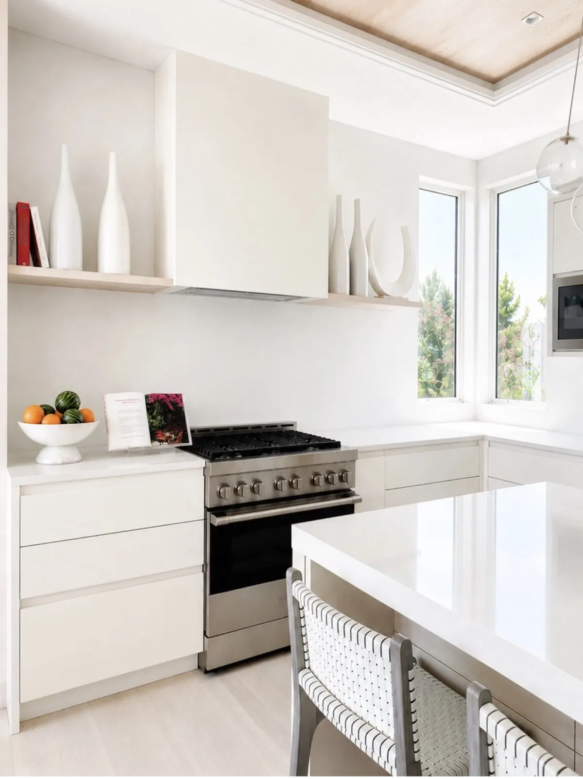Bright white kitchen with a fruit bowl and styled open shelves