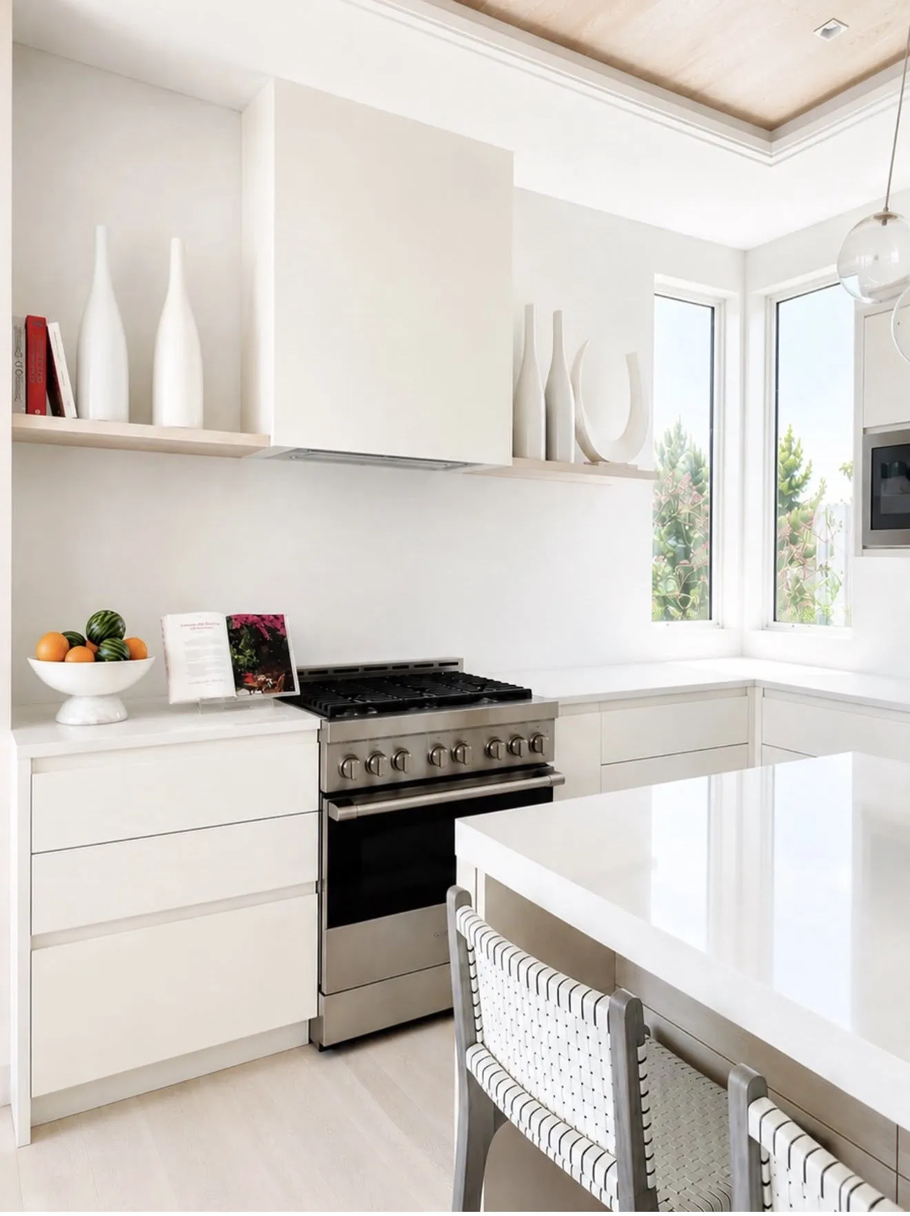 Bright white kitchen with a fruit bowl and styled open shelves