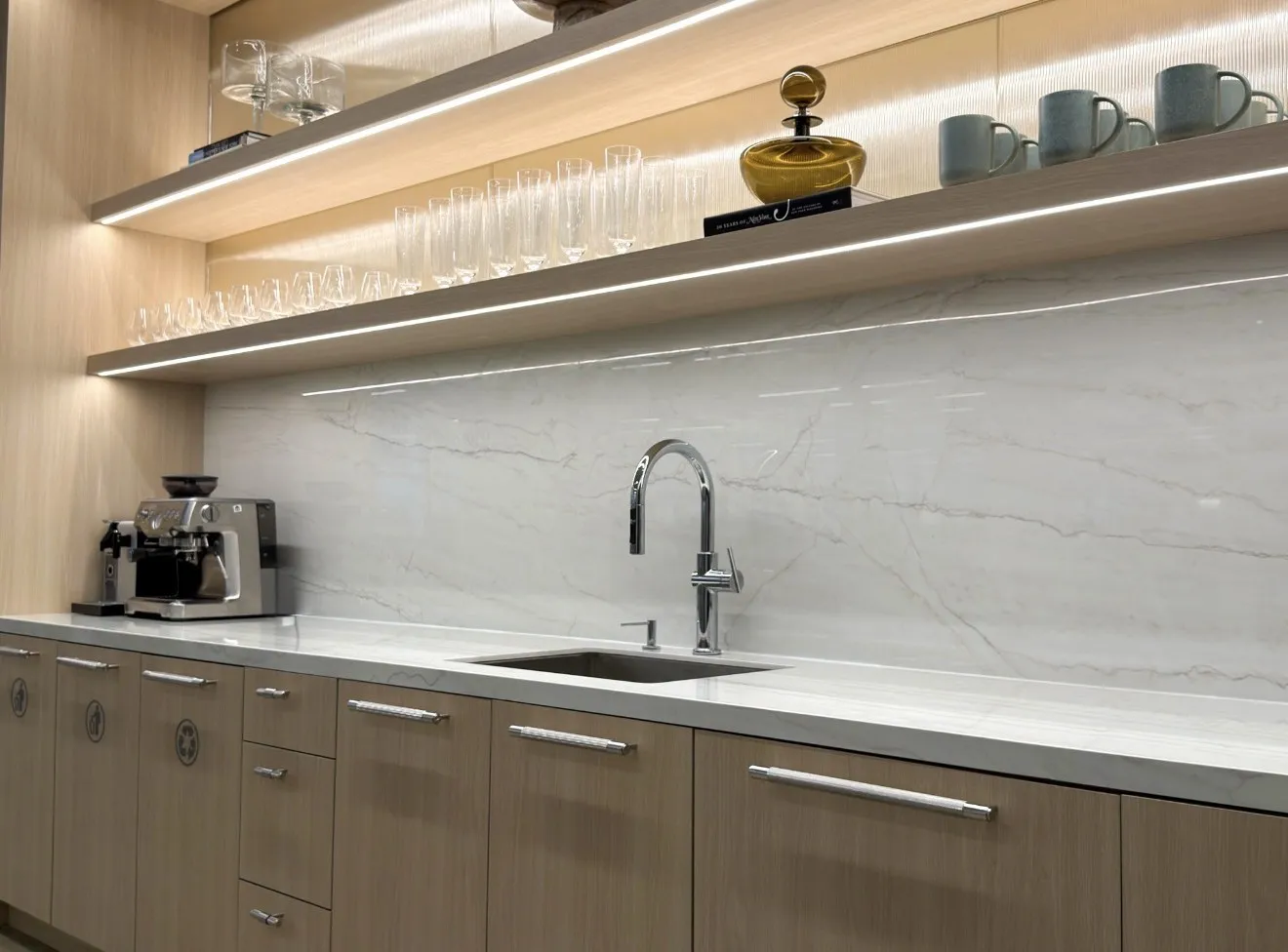 The corporate café bar with marble backsplash, coffee station and styled upper shelves