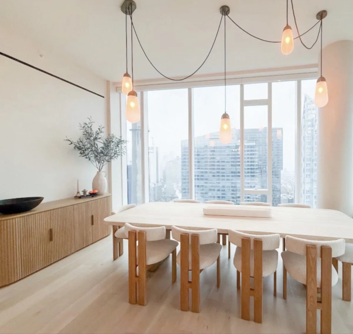 Dining room with wood furniture, pendant lights, and city views