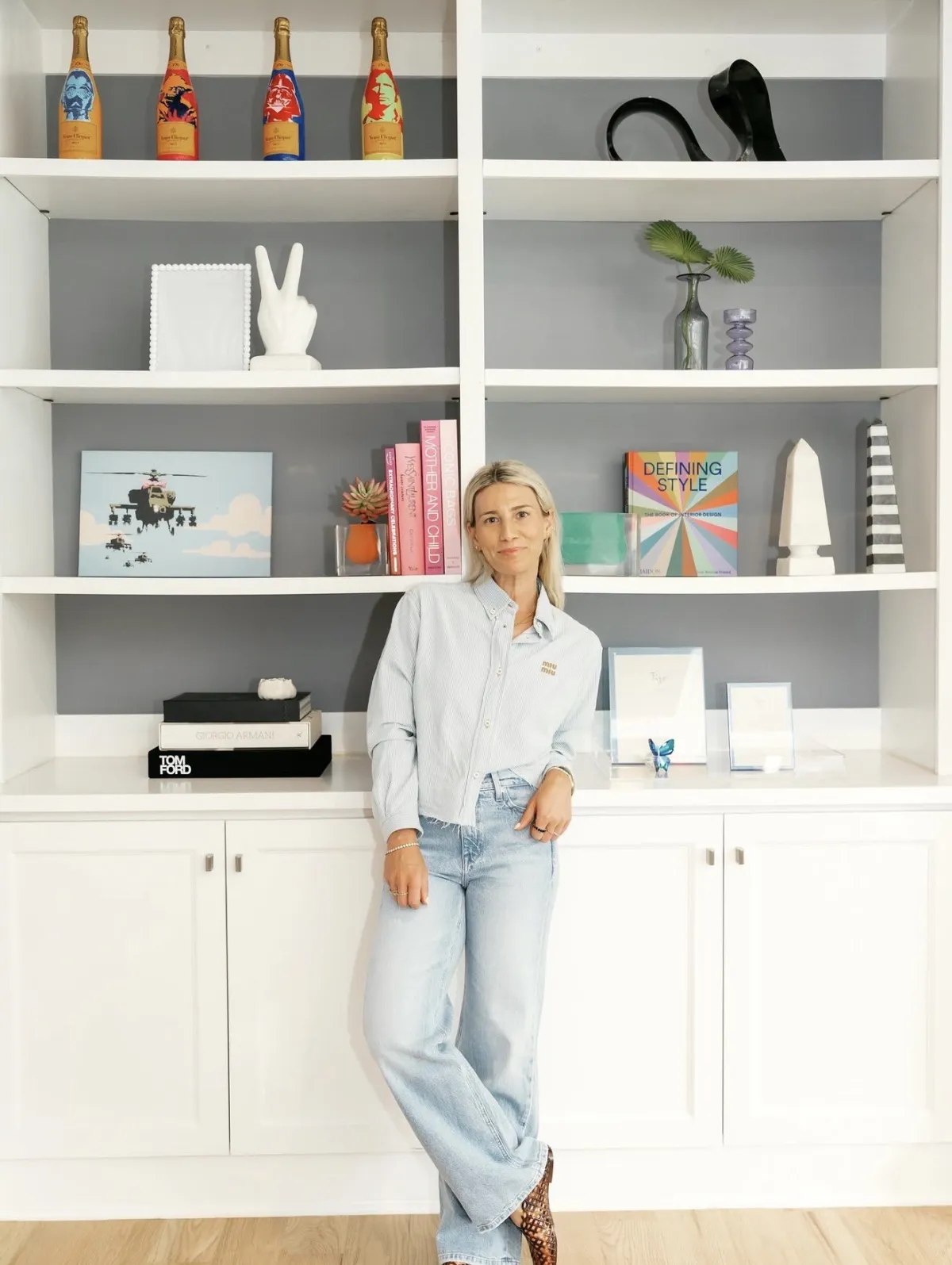 Marisa Sobol standing in front of colorful built-in shelves she styled