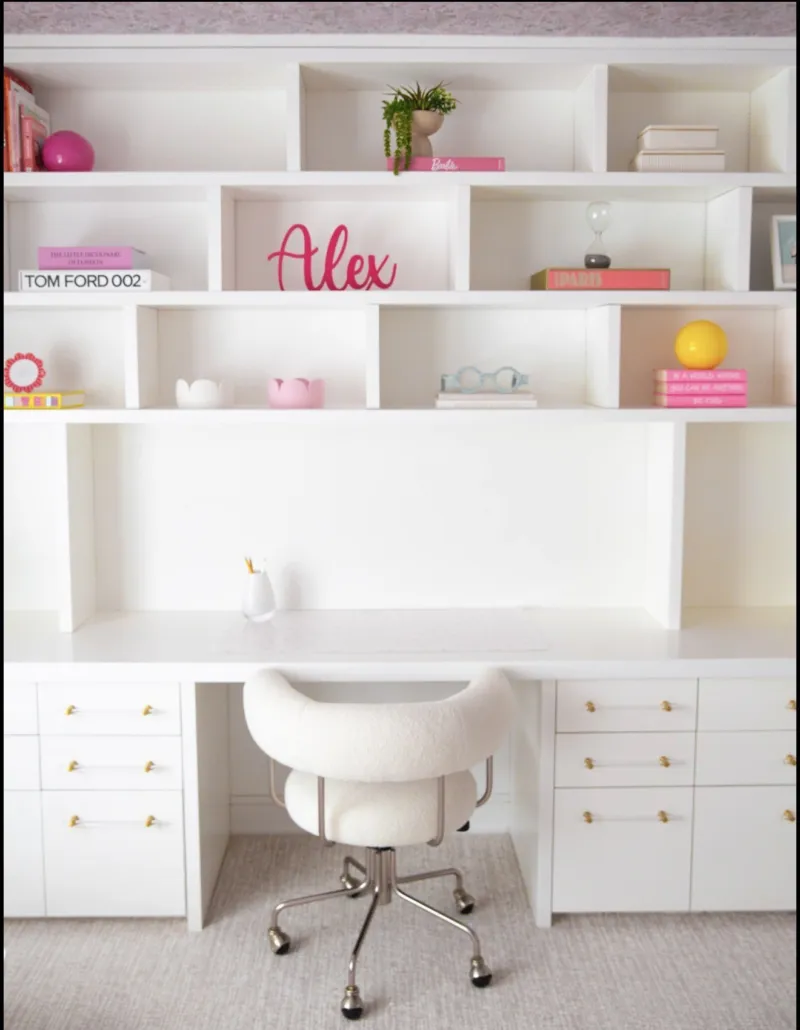 White built-in desk and shelves with pink accents in a Short Hills home