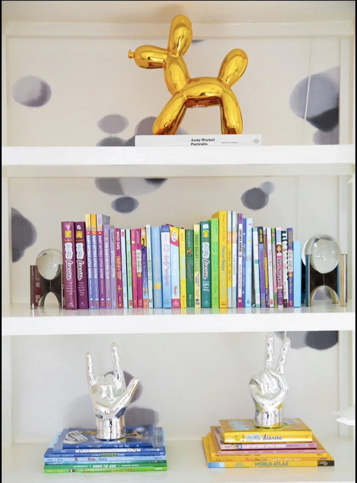 Books and sculptural objects on a white shelf