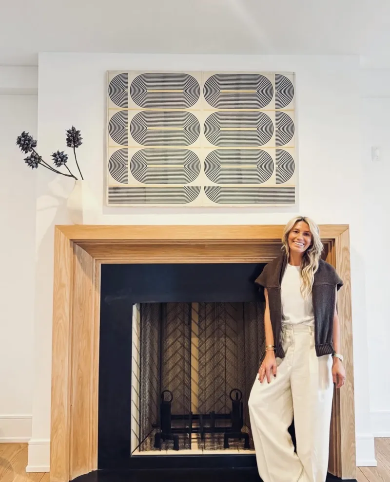 Marisa beside a wood-framed fireplace and graphic artwork in Short Hills