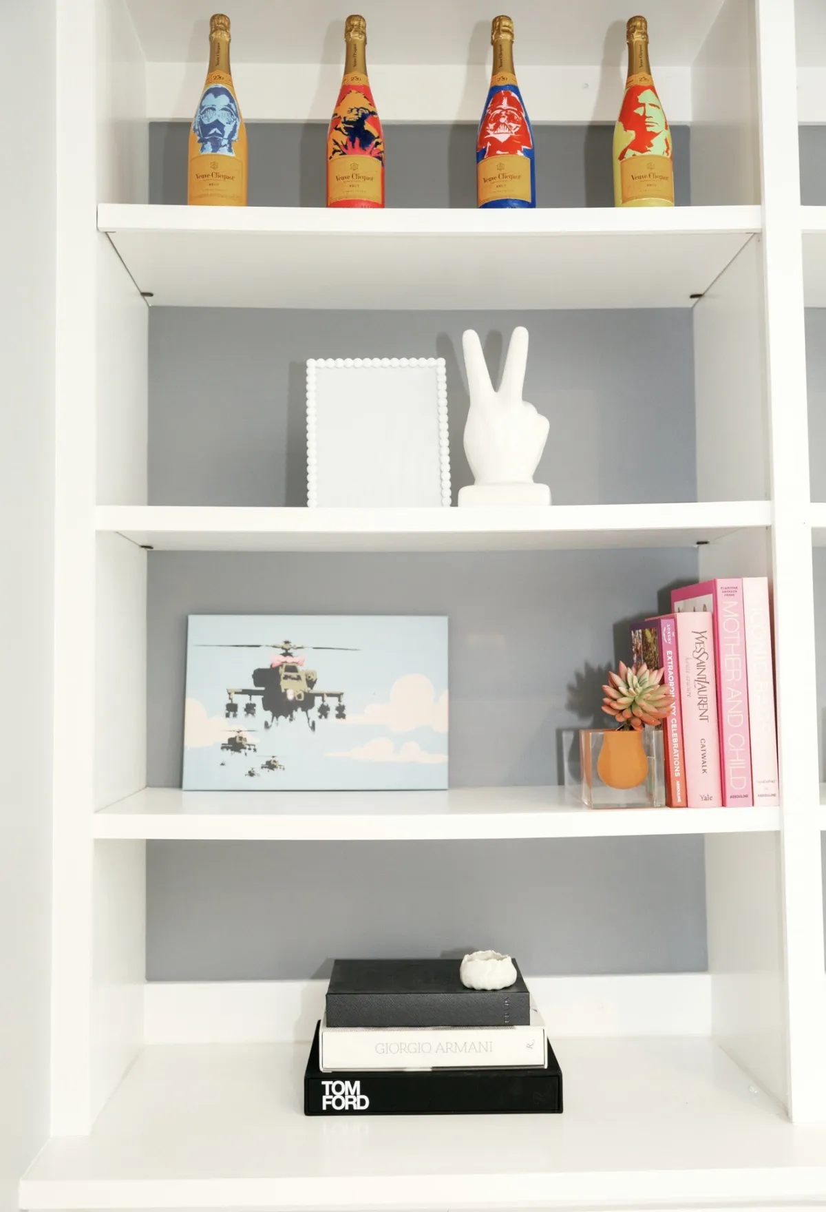White built-ins styled with champagne bottles, art, books and objects