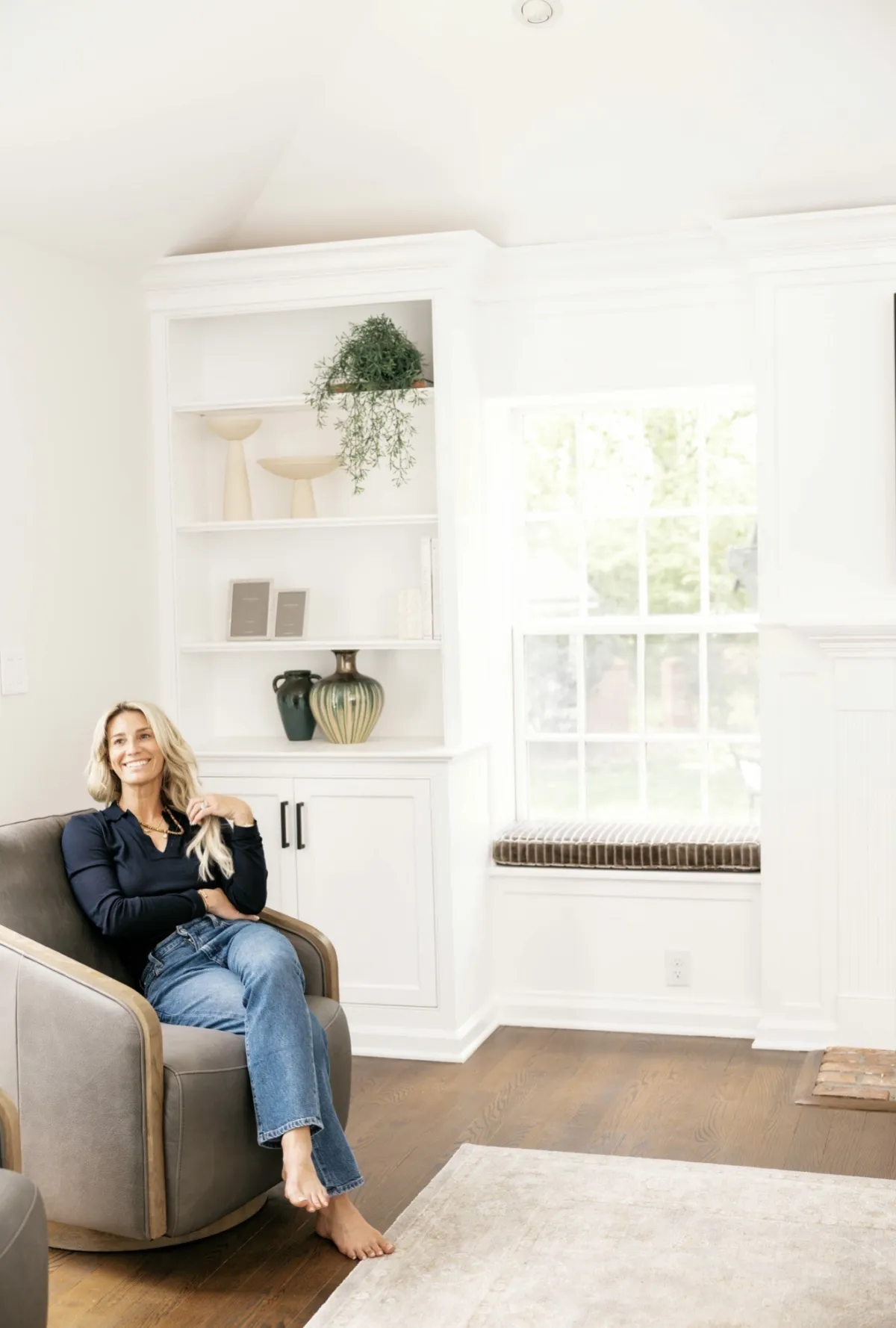 Marisa seated beside the styled shelves and window seat