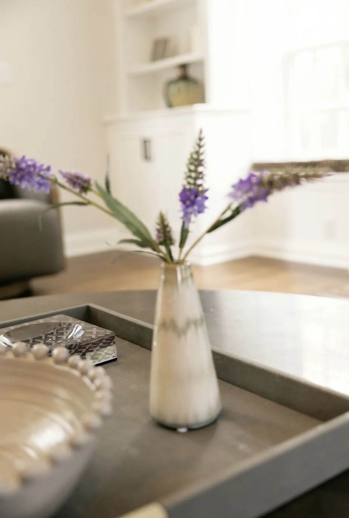 Detail of purple flowers and white bowl on the coffee table